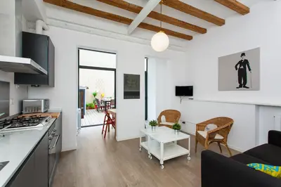 a kitchen and living room with white walls and wooden floors at Gracia Terrace in Barcelona
