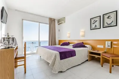 a hotel room with a bed and a large window at Gran Sol Hotel in San Pol de Mar