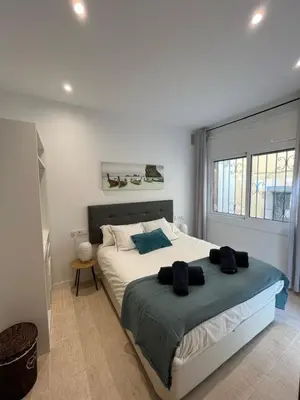 a bedroom with a large bed and a window at Apartamento St Zenon in Arenys de Mar