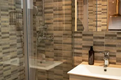 a bathroom with a shower and a sink and a glass shower at MonResidence La Figuereta in Manresa