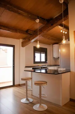 a kitchen with two stools and a counter top at MonResidence La Figuereta in Manresa
