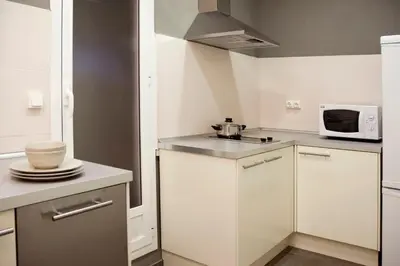 a small kitchen with white cabinets and a microwave at Barcelonaguest in Barcelona