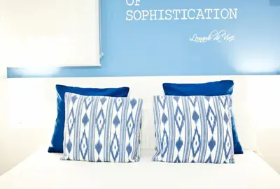 a bed with blue and white pillows on it at Petit Hotel in Barcelona