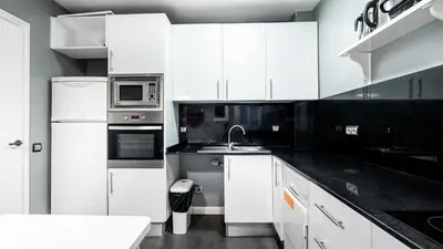 a kitchen with white cabinets and a sink at Magnificent 4 bedroom apartment in Eixample in Barcelona