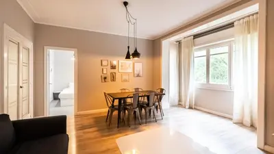 a dining room and living room with a table and chairs at Magnificent 4 bedroom apartment in Eixample in Barcelona