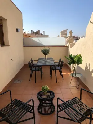 a patio with a table and chairs on a balcony at Vale Suites in Barcelona