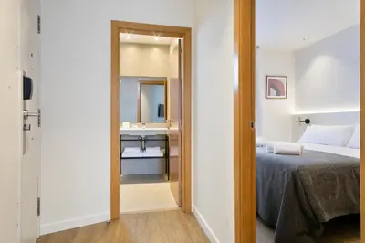 a bedroom with a bed and a mirror and a sink at Vale Suites in Barcelona