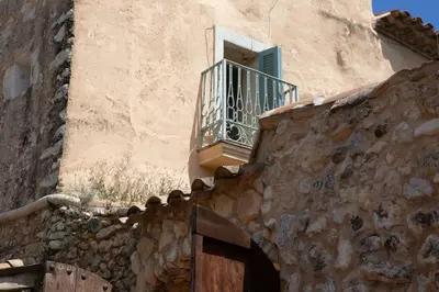 a stone building with a window and a balcony at Sitges Hill Retreats-Masia Nur 22 bedrooms divided over 9 houses for max 44 guests in Canyelles