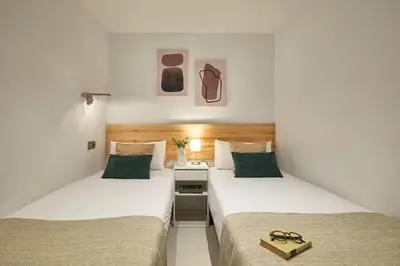 two beds in a hotel room with glasses on them at BBarcelona Diputació Flat in Barcelona