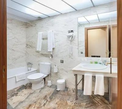 a bathroom with a toilet and a sink and a tub at Alba Hotel in Barcelona