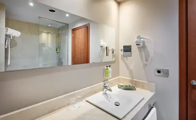 a bathroom with a sink and a mirror at Sercotel Ciutat de Montcada in Montcada i Reixac