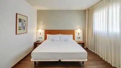 a bedroom with a large white bed and a window at Sercotel Ciutat de Montcada in Montcada i Reixac