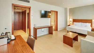 a hotel room with a bed and a table at Sercotel Ciutat de Montcada in Montcada i Reixac