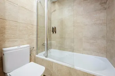 a bathroom with a shower and a toilet and a tub at Sweett - Casa Fira in Barcelona
