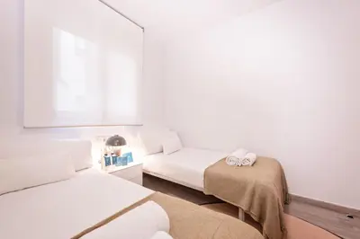 a small room with two beds and a window at Sweett - Casa Fira in Barcelona