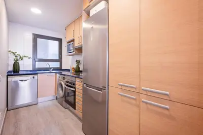 a kitchen with a stainless steel refrigerator and a dishwasher at Sweett - Casa Fira in Barcelona