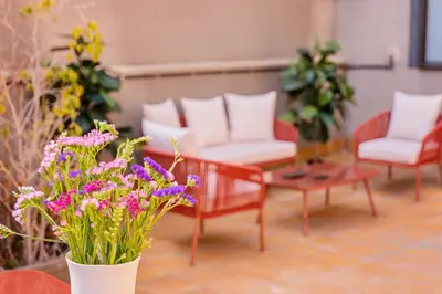 a living room with chairs and purple flowers at Sweett - Casa Fira in Barcelona