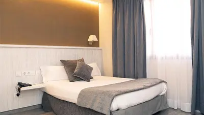 a hotel room with a bed with a window at Hotel Coronado in Barcelona