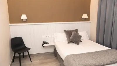 a hotel room with a bed and a chair at Hotel Coronado in Barcelona