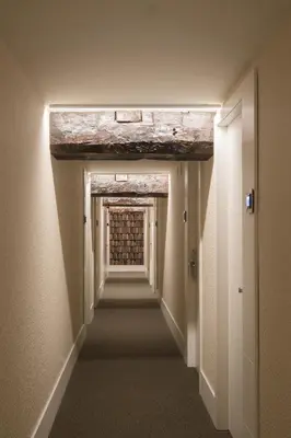a long hallway with a brick wall in a building at Hotel Sant Agustí in Barcelona