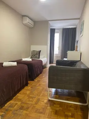 a hotel room with two beds and a couch at Somnio Hostels in Barcelona