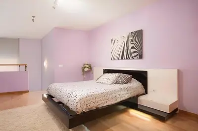 a bedroom with a bed and a painting on the wall at Vale Beach in Barcelona