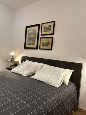 a bedroom with a bed with three pictures on the wall at Chic apartment beach in Mataró