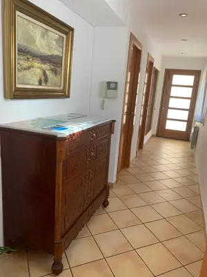 a hallway with a dresser and a painting on the wall at Chic apartment beach in Mataró