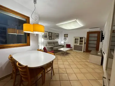 a kitchen and living room with a table and chairs at Chic apartment beach in Mataró