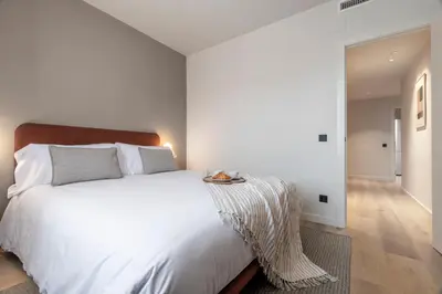 a bedroom with a white bed with a table on it at Arrivo Apartments in Barcelona