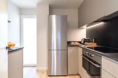 a kitchen with a stainless steel refrigerator at Arrivo Apartments in Barcelona