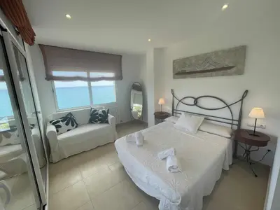 a bedroom with a bed and a couch in it at Villa Farell just in front of the sea in San Pol de Mar