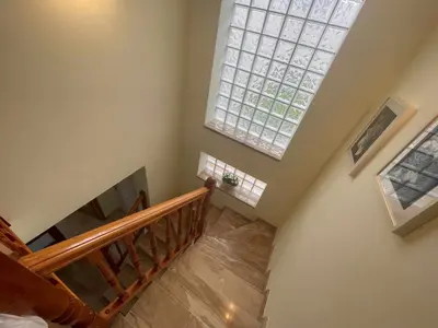 an overhead view of a staircase with a large window at Villa Farell just in front of the sea in San Pol de Mar