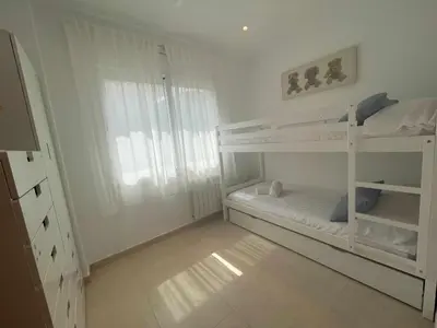 a bedroom with two bunk beds and a window at Villa Farell just in front of the sea in San Pol de Mar