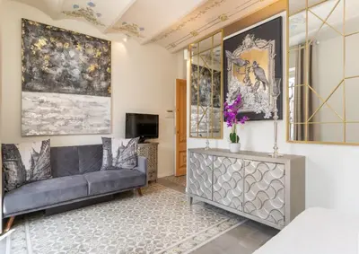 a living room with a couch and a tv at El Petit Palauet in Canet de Mar