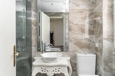 a bathroom with a sink and a toilet and a mirror at El Petit Palauet in Canet de Mar