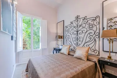 a bedroom with a bed with a large headboard at El Petit Palauet in Canet de Mar