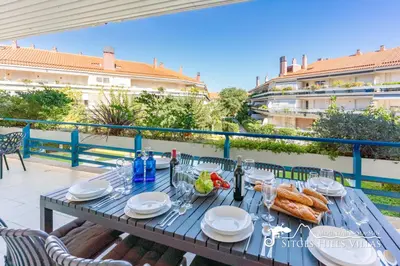 a large apartment building with a tennis court in a park at Apt Parc Del Mar in Sitges very near Beach in Sitges