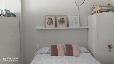 a bedroom with a bed with three pictures on a shelf at Studio doria in Sant Boi del Llobregat