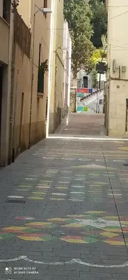 an empty alley with a rainbow painted on the sidewalk at Studio doria in Sant Boi del Llobregat