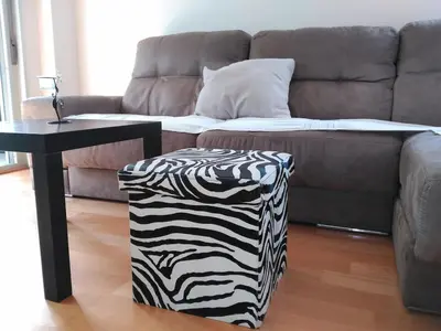 a zebra print ottoman in a living room with a couch at 3 BEDROOMS, 2 BATHROOMS FOR 6 PAX, SWIMMING POOL, FREE PARKING and NEAR THE BEACH! in Sant Adria de Besos