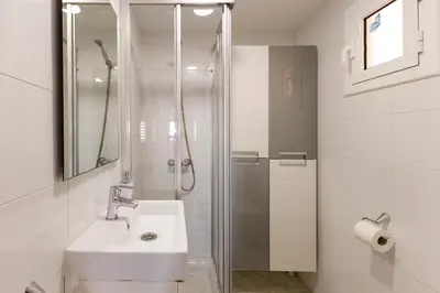 a white bathroom with a sink and a shower at Barcelona Sunny Terrace in Hospitalet de Llobregat