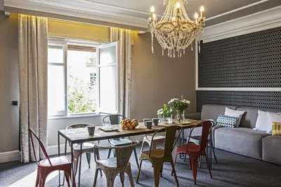 a dining room with a table and chairs and a chandelier at AinB B&B Eixample-Muntaner in Barcelona