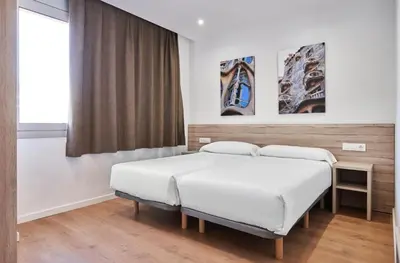 a bedroom with two beds and a window at Aparthotel Augusta in Barcelona