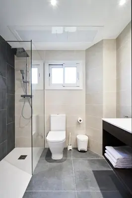 a bathroom with a toilet and a glass shower at Aparthotel Augusta in Barcelona