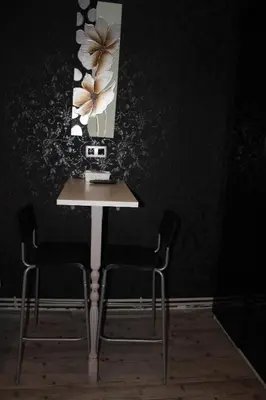a table with two chairs and a picture on the wall at BCN Condal Hostal in Barcelona