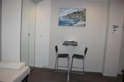 a room with two chairs and a table with a painting on the wall at BCN Condal Hostal in Barcelona