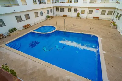 a large blue swimming pool in a courtyard of a building at HomeHolidaysRentals Cyan- Costa Barcelona in Pineda de Mar