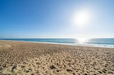 a sandy beach with the ocean in the background at HomeHolidaysRentals Cyan- Costa Barcelona in Pineda de Mar