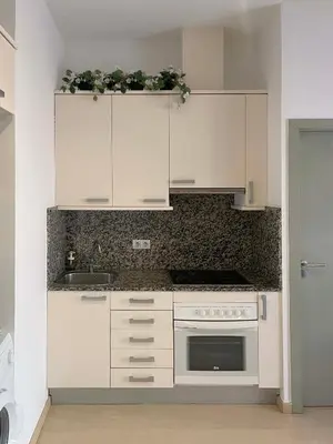 a kitchen with white cabinets and a stove at SF Apartamento céntrico con terraza in Terrassa